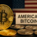 米国旗を背景に「AMERICAN BITCOIN」と書かれた札と金色のビットコインのコインが写る接写写真