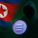 北朝鮮の国旗とフードを被ったハッカー、Solanaロゴと暗号コードの背景