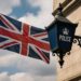 英国政府が公共部門と重要インフラにおけるランサムウェア身代金支払い禁止を検討する提案を象徴するイメージ。ロンドンの行政ビルとデジタルセキュリティの概念を融合。